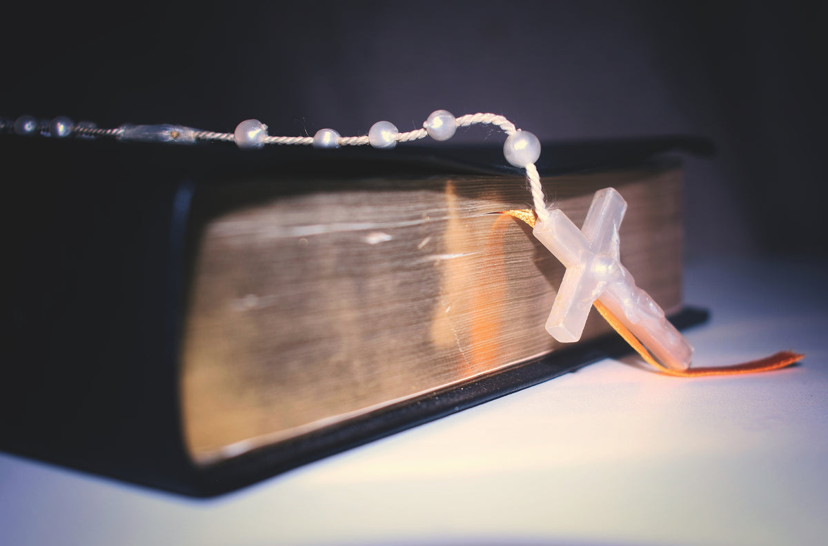 Rosary resting on a Bible in a soft light