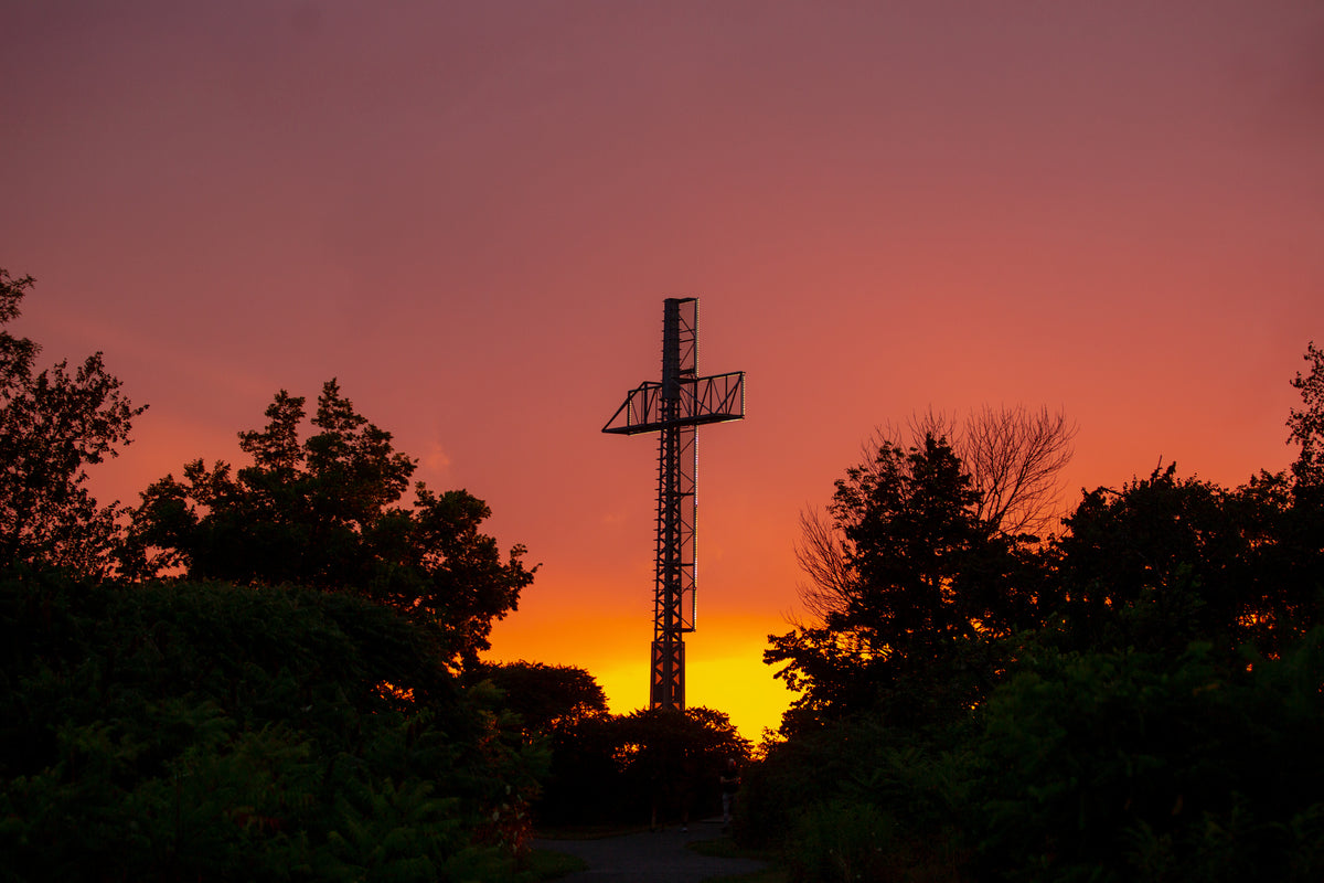 Silhouette of a cross against a sunset background